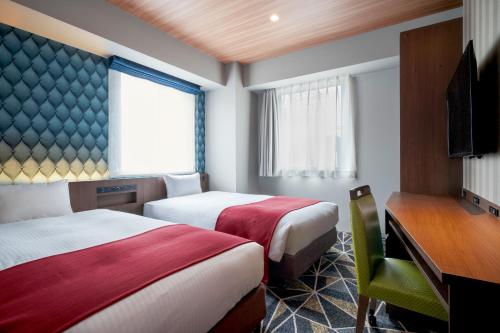 札幌the b sapporo的酒店客房设有两张床和电视。