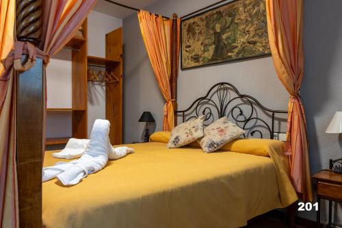 乌娜Hotel Uña Serranía Encantada的一间卧室配有一张带黄色床单和枕头的床。