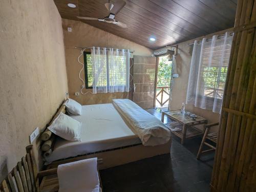 KhāpaAthulyam Kanha, kanha national park, mukki gate的一间小卧室,配有一张床和一张桌子