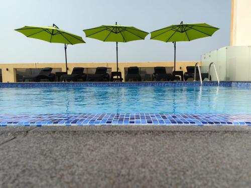 吉达Rosemond Al Hamra的一个带椅子和遮阳伞的游泳池