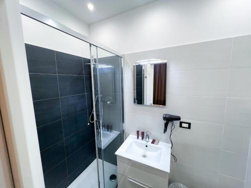米兰米兰罗索维诺酒店的一间带水槽和玻璃淋浴的浴室