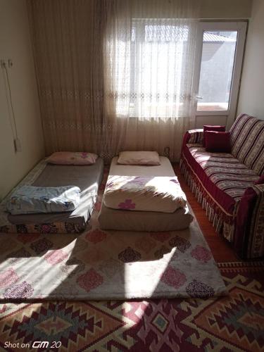 TatvanTatvan Merkezde Sahile Yakın Eviniz的一张沙发和一个窗户的房间里设有三张床