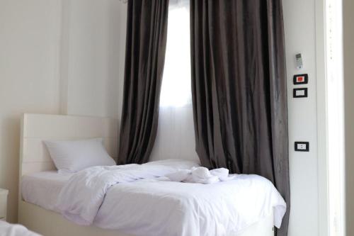 卢克索Diamond Guest House的一间卧室配有一张带白色床单的床和一扇窗户。
