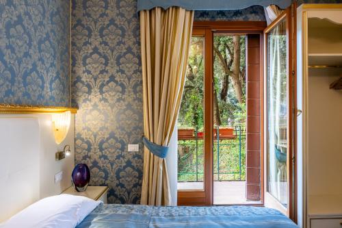 威尼斯威尼斯商人酒店的一间卧室设有一张床和一个滑动玻璃门
