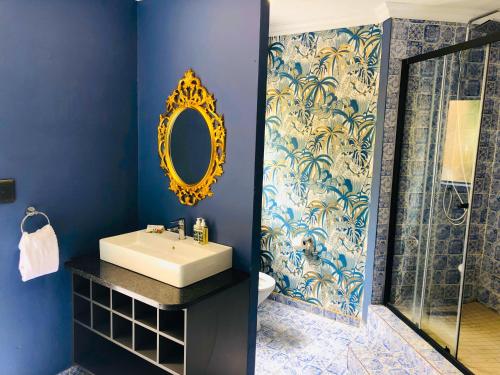 贝拉贝拉Grafiti Boutique Hotel的一间带水槽和镜子的浴室