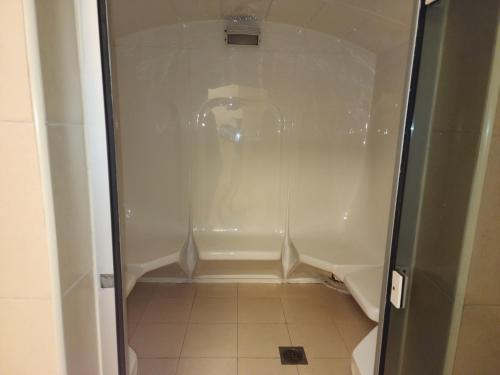 迪拜Elite 6 Sports Residence by Golden Casa的浴室铺有瓷砖地板,配有白色淋浴。