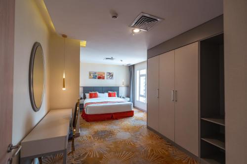 科威特Wahaj Boulevard Hotel Apartmentوهج بوليفارد للشقق الفندقية的一间卧室配有一张床和一个大衣柜