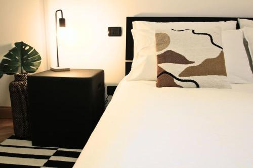 罗马Ecosuite your design Escape的一间卧室,配有一张带植物和灯的床