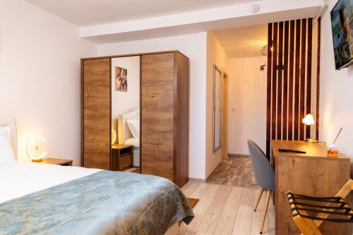 德罗贝塔-塞维林堡Apartament ALESSIO的酒店客房配有一张床、一张桌子和一把椅子。