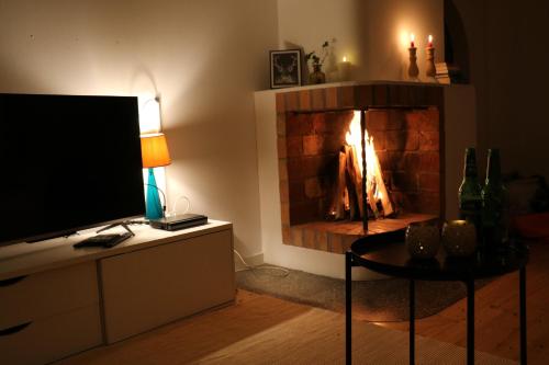BrograngenBograngen LGH D的客厅设有壁炉、电视和桌子