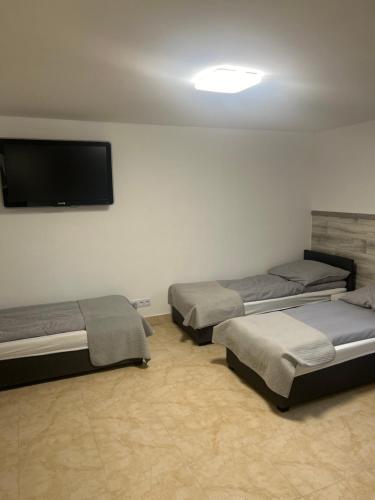 乔左维尔考普尔斯基Hostel 24 Miejsca Parkingowe Noclegi Pracownicze.的客房设有三张床和一台平面电视。