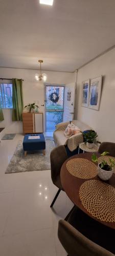 武端市Cassie Homestay - Yuna Door 2 - Furnished Home in Butuan的客厅配有桌子和沙发