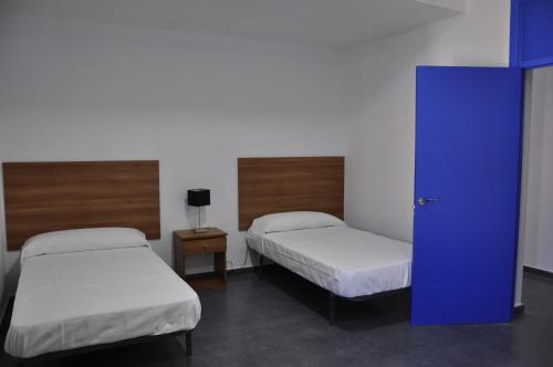 ChelesCruceros Alqueva的一间设有两张床和蓝色门的房间