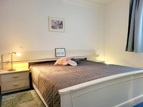 奥斯赛拜-屈隆斯博恩Appartementhaus Olymp的一间卧室配有一张大床和木制床头板