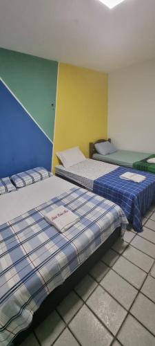 纳塔尔Hotel Beira Mar的两张睡床彼此相邻,位于一个房间里