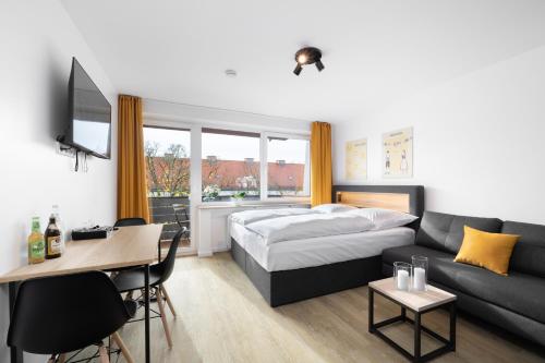 慕尼黑Homaris Apartments München Laim的酒店客房,配有床和沙发