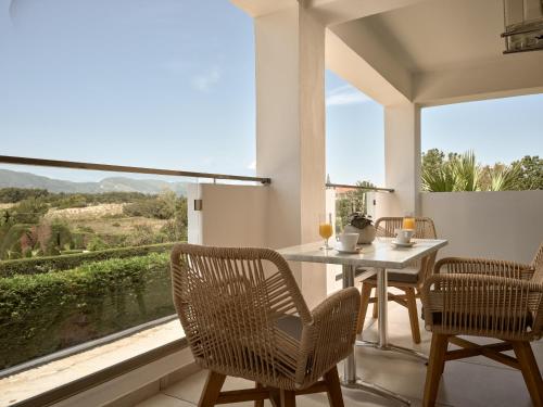 卡拉马孔Marelen Hotel Zakynthos的一间带桌椅和大窗户的用餐室