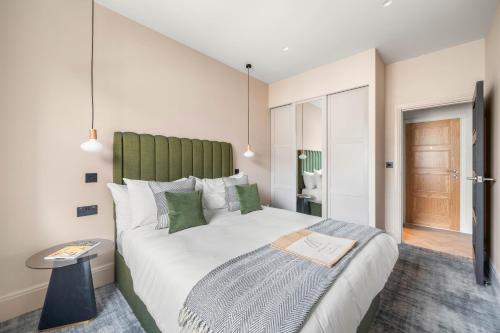 伦敦Kentish Town Road的一间卧室配有一张大床和绿色床头板
