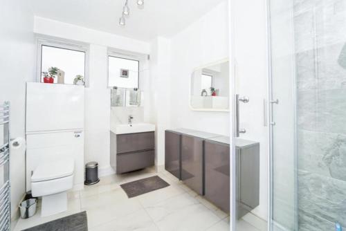 伦敦Spacious modern family bedroom in Central London的带淋浴、盥洗盆和卫生间的浴室