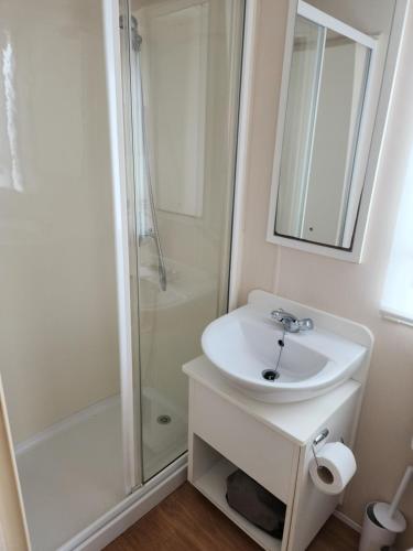 英戈尔德梅尔斯Sam's Caravan Hire Coastfield Holiday Village Ingoldmells的白色的浴室设有水槽和淋浴。