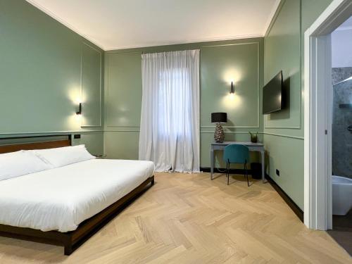 博洛尼亚Mondo7的一间卧室配有一张床、一张书桌和一个窗户。