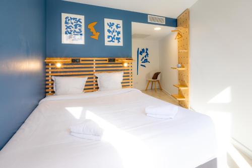马赛The People - Marseille的一间卧室配有一张带两个白色枕头的大床