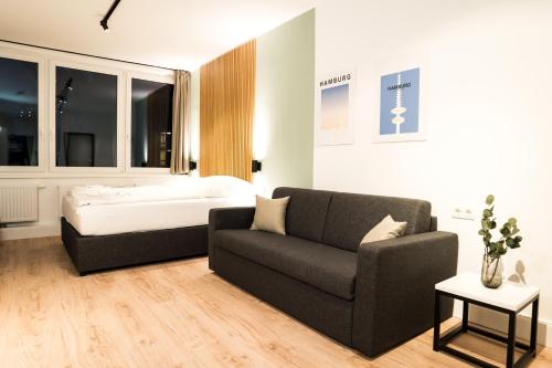 汉堡Homaris Apartments Hamburg Altona的客厅配有沙发和1张床