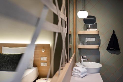 维也纳ARCOTEL AQ Wien的一间带水槽和镜子的小浴室