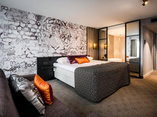 马斯特里赫特马斯特里赫特凡德瓦克酒店的一间卧室配有一张床和涂鸦墙