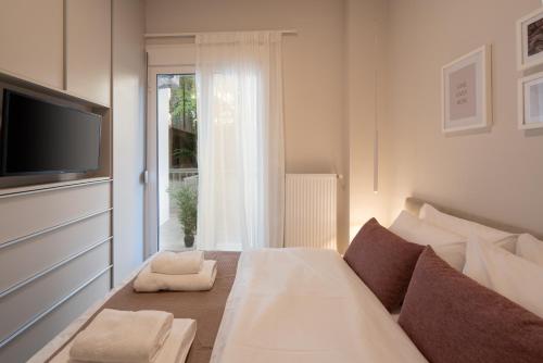 雅典Charming two bedrooms Apartment walk to Acropolis的一间卧室设有一张床、一台电视和一个窗口。