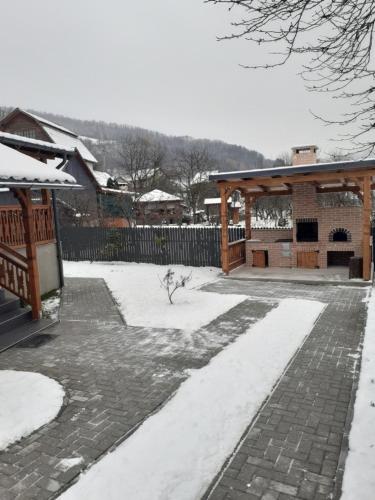 上维谢乌Casa Edy的一个带凉亭的雪覆盖庭院