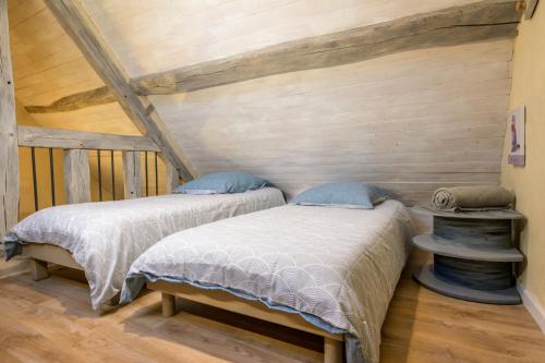 Marigné-LailléGîte Les Toisnières的木墙客房的两张床