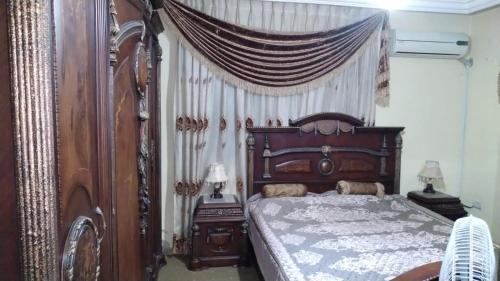 伊尔比德Jad apartment的一间卧室配有一张木床和天篷