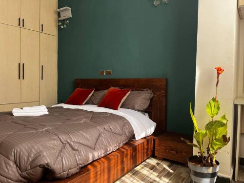 亚的斯亚贝巴ጉዲት:ቤት /Haus of GOODiT的一间卧室配有一张带红色枕头的大床