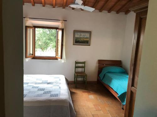 斯卡尔佩里亚Poggio Savelli的一间卧室设有两张床和窗户。