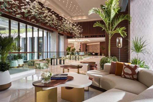 迪拜Anantara Downtown Dubai的大堂配有沙发、桌子和植物
