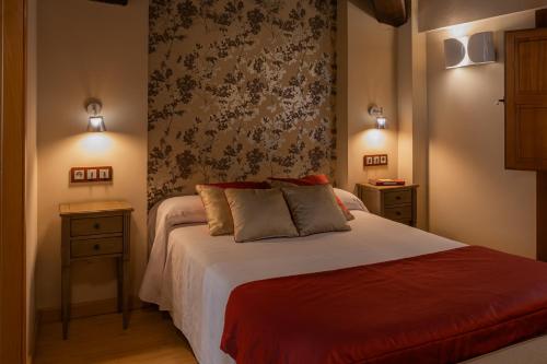 埃尔瓦厄尔罗梅罗公寓的一间卧室,配有一张带两个床头柜和一面墙的床