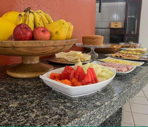 圣路易斯SÃO CRISTOVÃO HOTEL的装有水果碗和食物盘的柜台