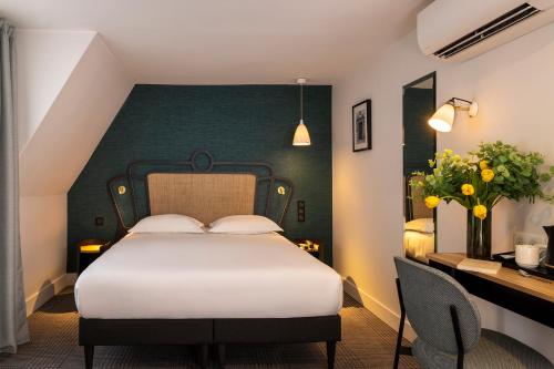 巴黎苏伊士酒店的卧室配有白色的床和绿色的墙壁