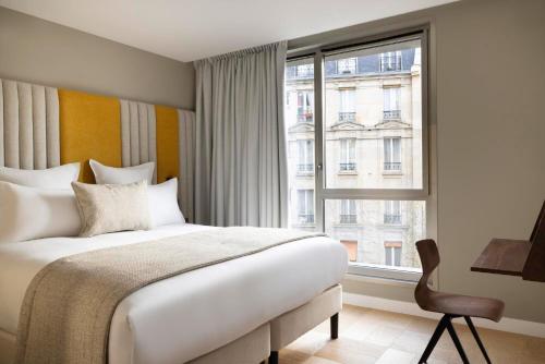巴黎Hôtel Pilgrim的一间卧室设有一张床和一个大窗户