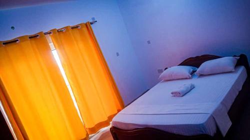 蒙巴萨Three Bedroom at Nyali的橙色窗帘的房间的一张床位