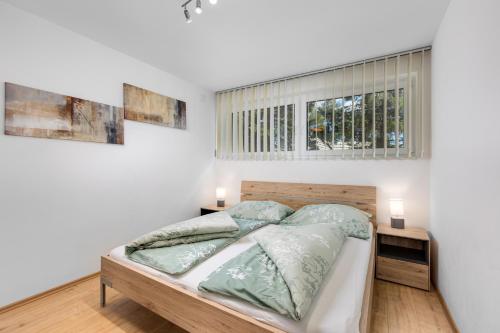 TreffenGerlitzenzeit的一间卧室设有一张床和两个窗户。