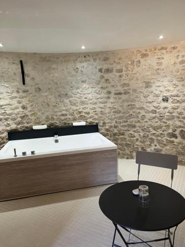 BeauvilliersFerme de Mesangeon的带浴缸的客房内配有桌椅