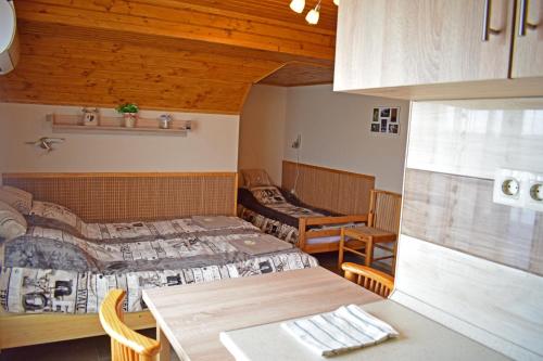 波罗斯洛Tündérfátyol vendégház的一间设有两张床和一张桌子及椅子的房间