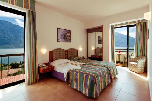 利莫内-苏尔加达Hotel Ilma Lake Garda Resort的酒店客房设有一张床和一个阳台。