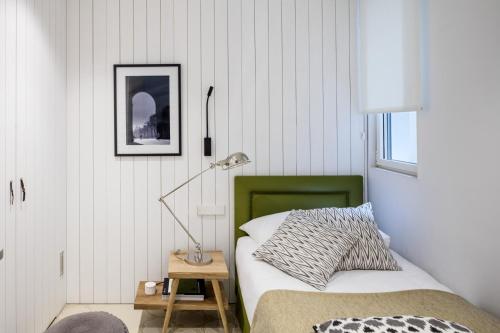 巴塞罗那The Onsider - Luxury 4 Bedroom Apartment的一间卧室配有一张床和一张桌子上的台灯