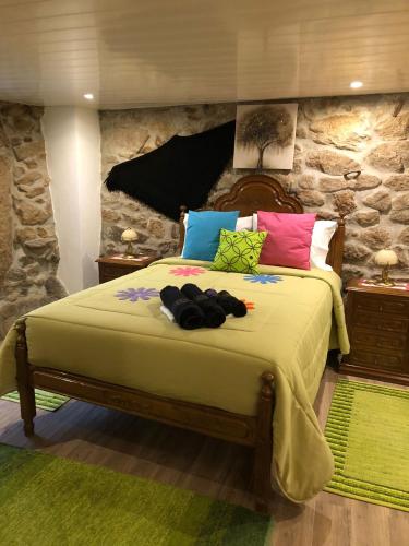 TaroucaCasas do Lobo的一间卧室配有一张带色彩缤纷枕头的大床