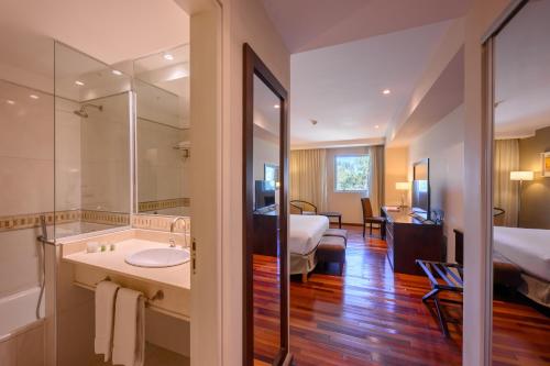 科尔多瓦Orfeo Suites Cordoba的酒店客房设有浴室和卧室
