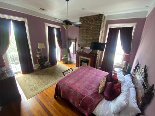 新奥尔良The Dragonfly Guest House的一间卧室设有一张大床和一个壁炉