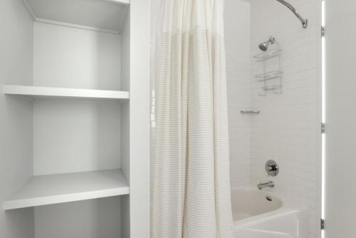旧金山Soma 1br w pool yoga spa nr station bars SFO-1476的白色的浴室设有淋浴帘和浴缸。